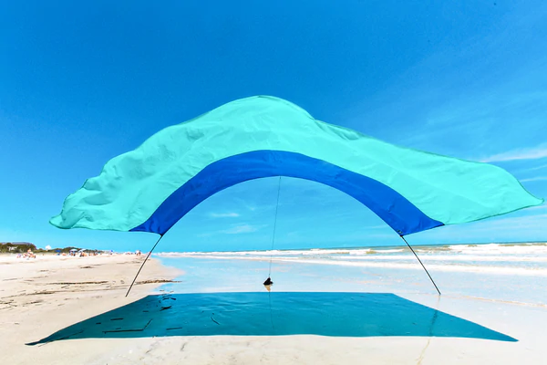 Shibumi shade open on beach in sand by waves